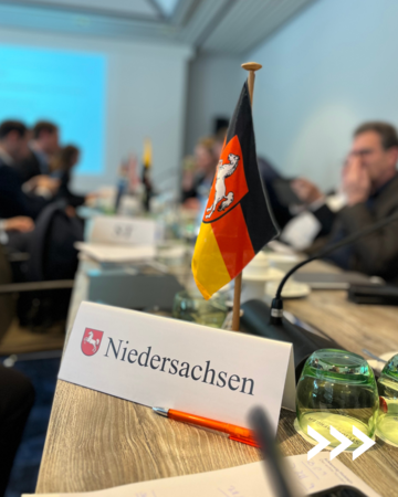 Tischschild Niedersachsen und Tischfahne von Niedersachsen im Konferenzraum der Jahresfinanzministerkonferenz