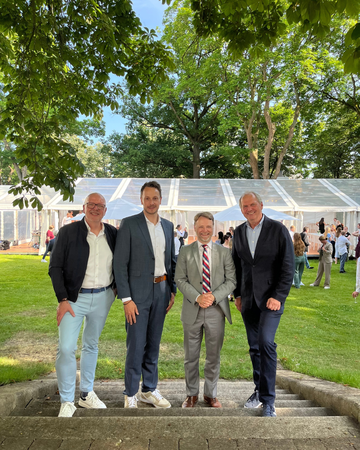 Finanzminister Gerald Heere mit drei Herren auf einer Treppe beim Sommerfest