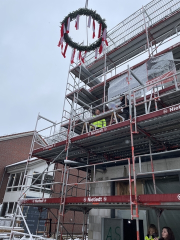 Der Richtkranz hängt oben am Gerüst des Rohbaus