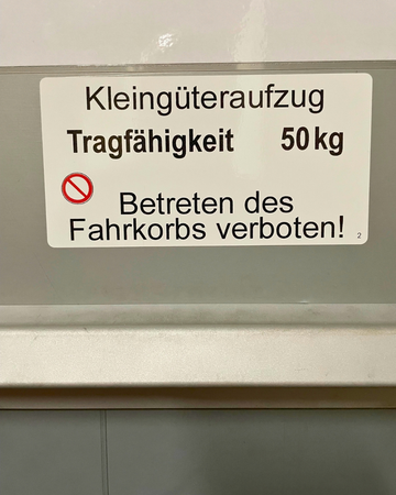 Schild: Kleingüteraufzug, Tragfähigkeit 50 kg, Betreten des Fahrkorbs verboten