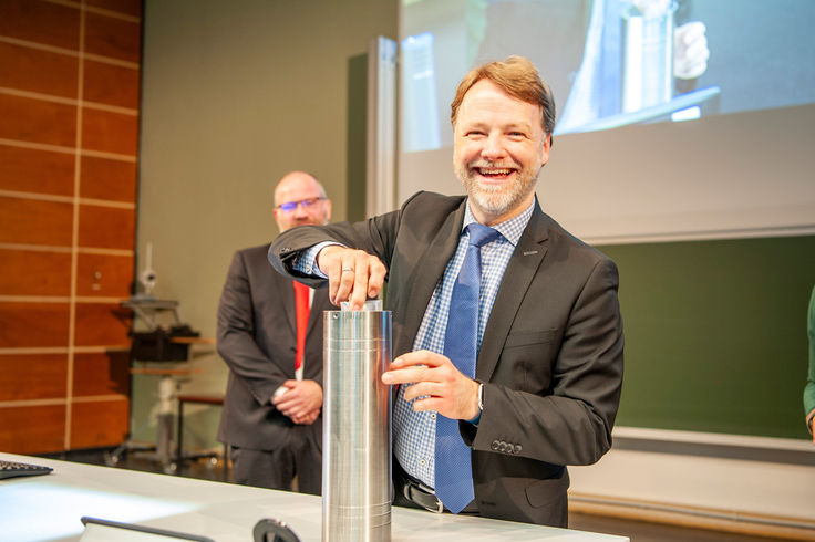 Finanzminister Heere befüllt eine Zeitkapsel