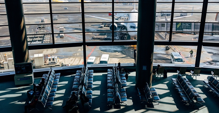 Wartebereich im Flughafen mit Fensterblick auf Flugzeuge im Außenbereich
