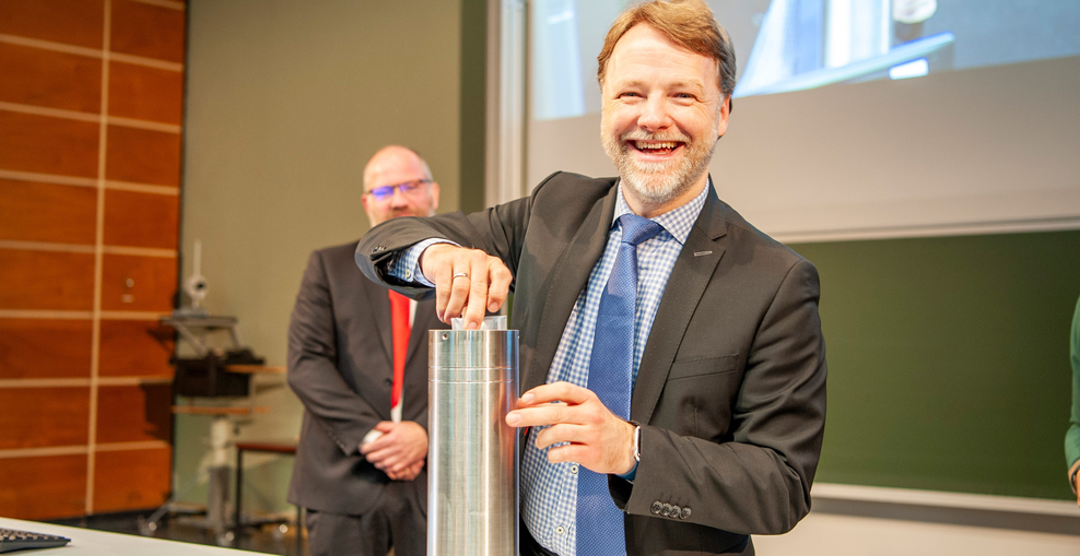 Finanzminister Heere befüllt eine Zeitkapsel