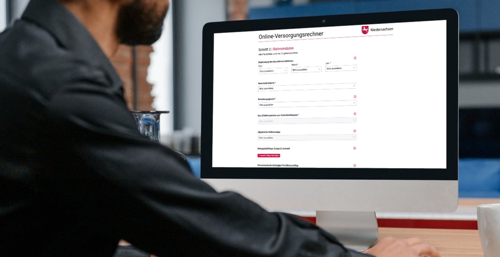 Mann sitzt vor einem Bildschirm, auf dem der Online-Versorgungsrechner geöffnet ist